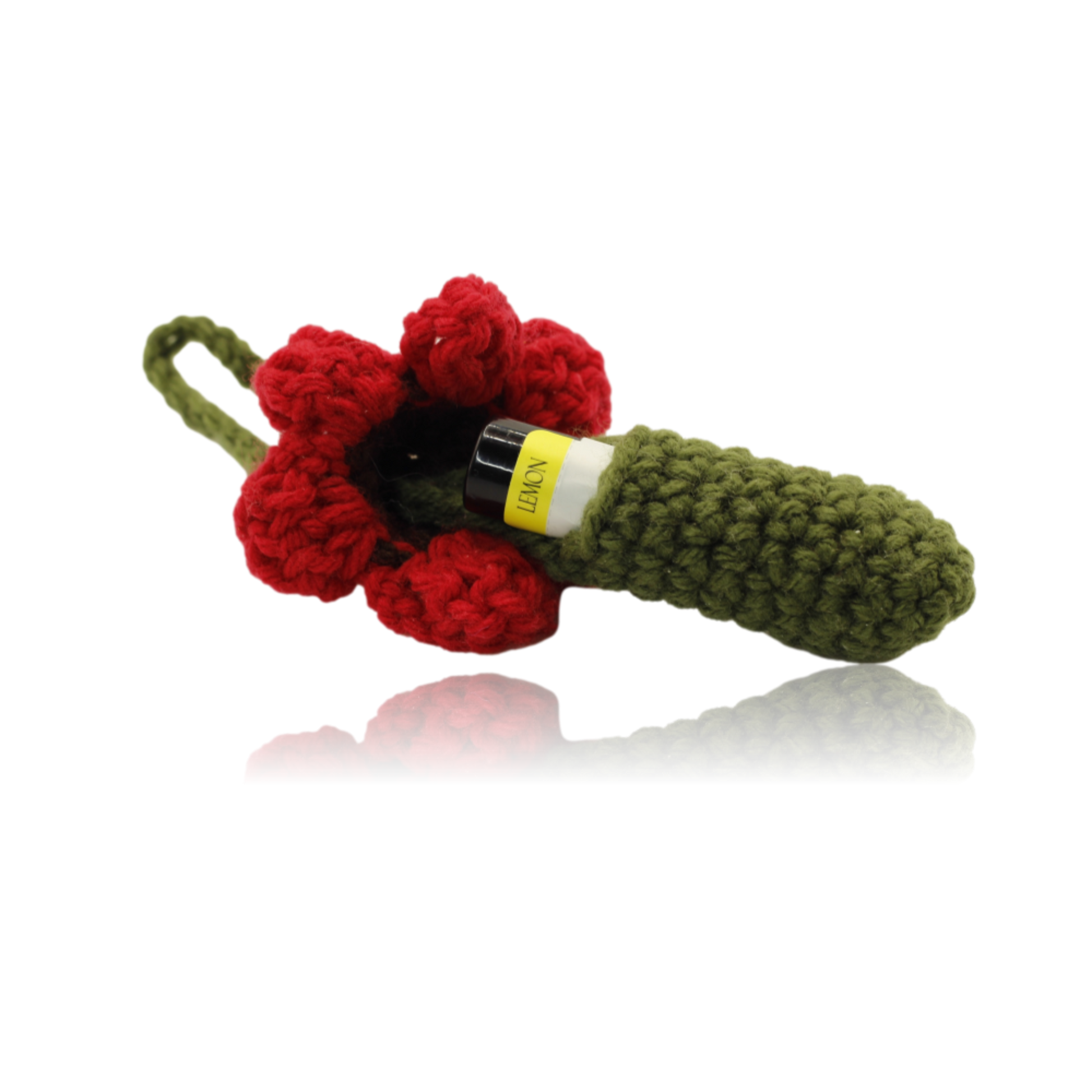 Crocheted flower and green stem with a yellow label on a white background